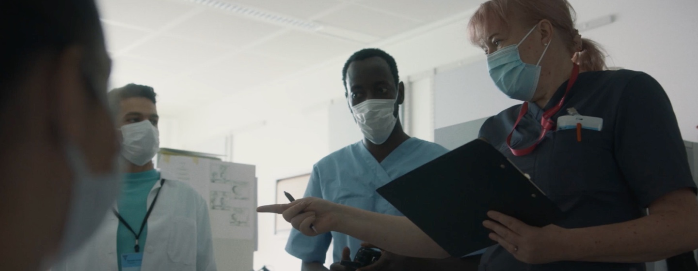 Captura de video de 4 trabajadores de at. médica, 1 sostiene un portapapeles, señala mientras otros miran.