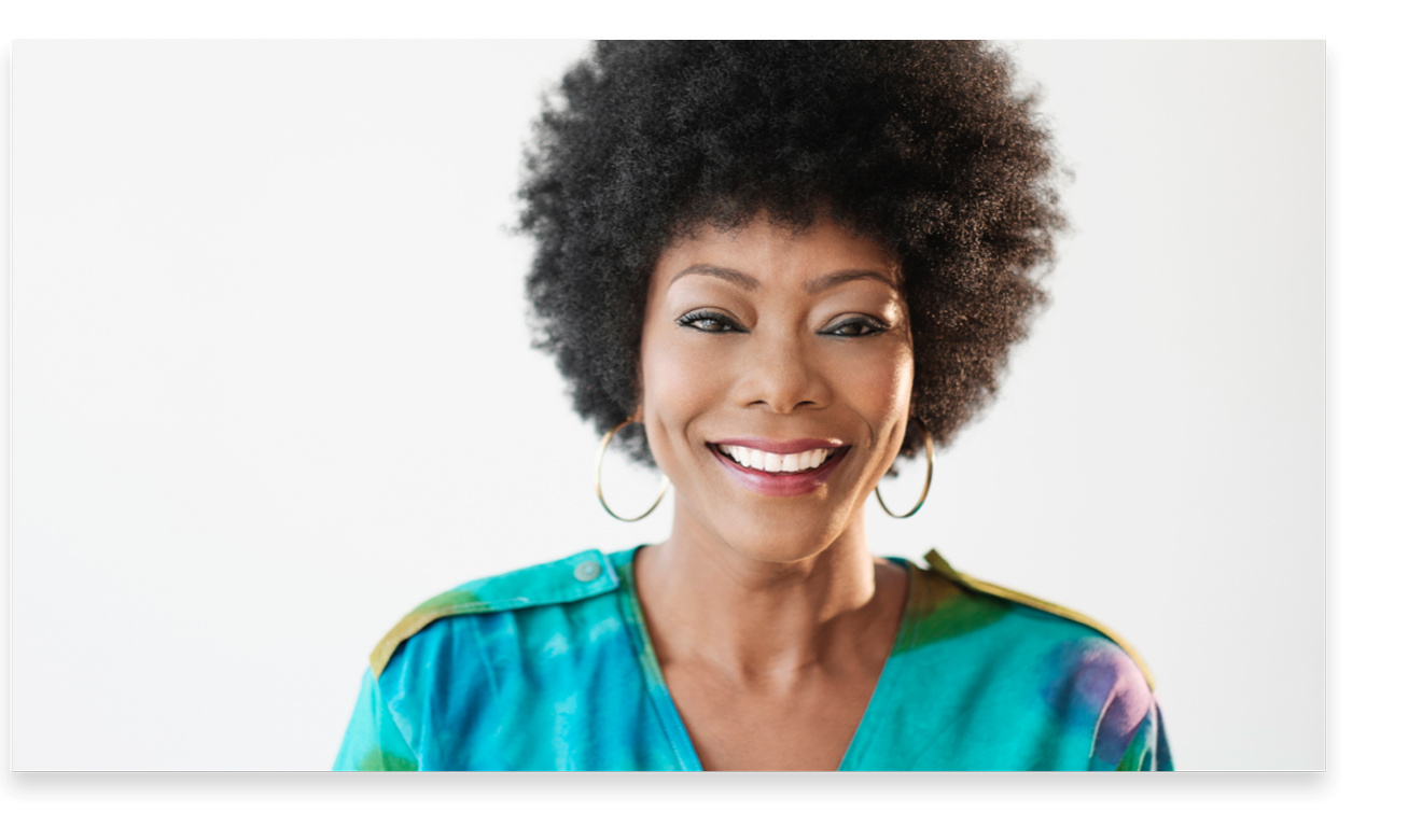 Smiling woman with hoop earrings and afro.